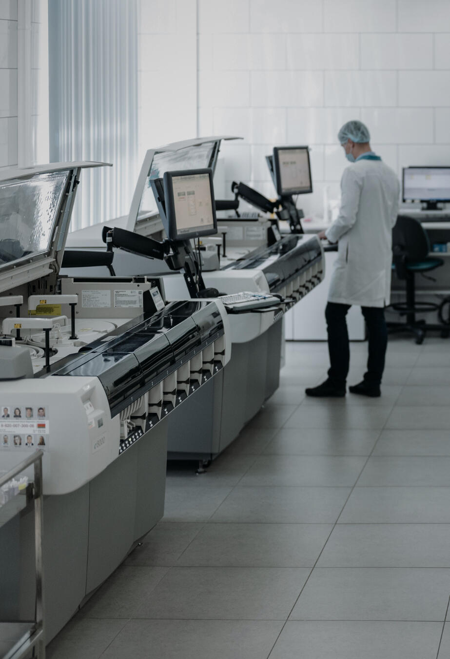 Photo of a modern diagnostic laboratory with a technician operating high-end analyzers, representing Health Stat's send-out lab services